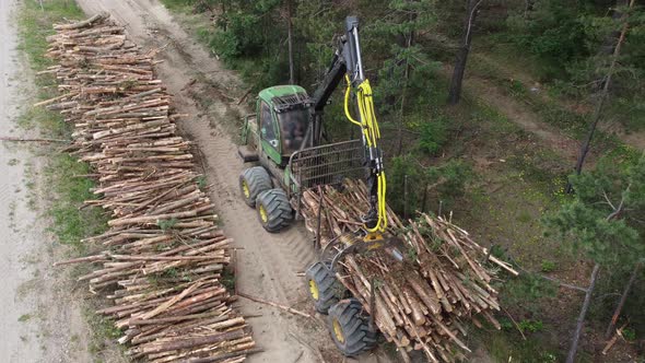 Aerial shot, deforestation for Industrial production, mechanical gripper loading lumber alt