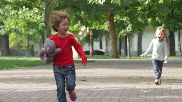 Happy Girl Running It Park with Her Sister Together. Slow Motion alt