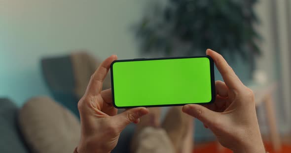 Man Holding Smartphone with Green Mock Up Screen