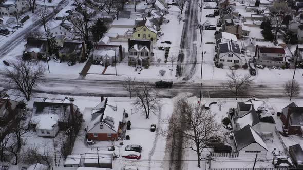 an aerial view over a suburban neighborhood in the morning, after a snow storm. The drone camera dol alt