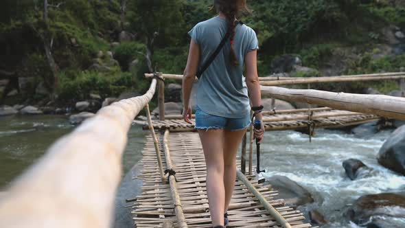 Woman on Bridge Over Fast Mountain River Thailand