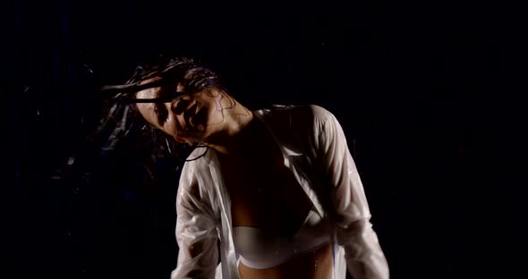 Portrait of Beautiful Sexy Girl in White Shirt and White Underwear. She Stands on a Black Background alt