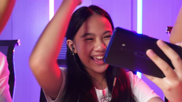 Face Of Asian Team Gamers Playing In Competitive Video Games By Mobile Phone And Celebrate Win alt