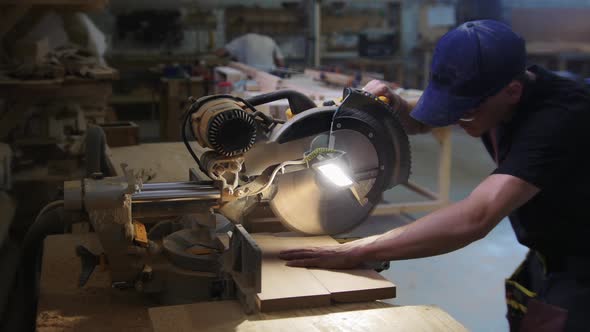 Carpentry Works in Workshop Man Worker Cutting the Pieces of the Wooden Desk Using a Big Circular alt