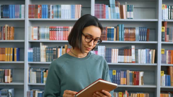 A Young Female Millennial Student Writes an Assignment in Her Notebook While Standing in a Public