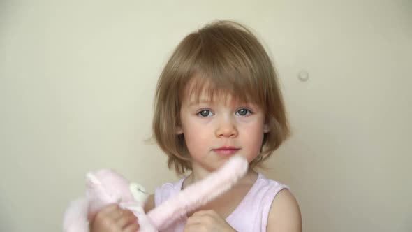 Portrait of Little Girl Hugs Toy Teddy Bear Looks at Camera and Smiles