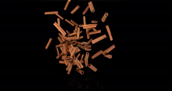 Cinnamon sticks, cinnamomum zeylanicum, spice falling against Black Background, Slow Motion 4K alt