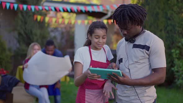 Happy African American Brother and Sister Surfing Internet on Tablet As Blurred Couple of alt