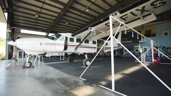 Small passenger plane in an airport hangar. alt