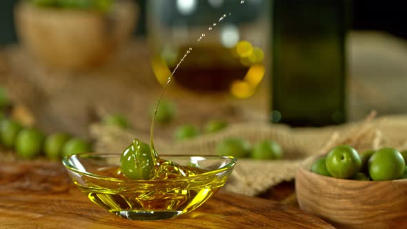 Super Slow Motion Shot of Fresh Olive Splashing Into Olive Oil at 1000 Fps alt