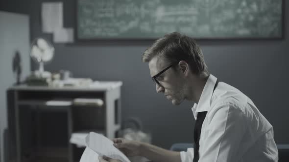 Young mathematician checking his research in the office