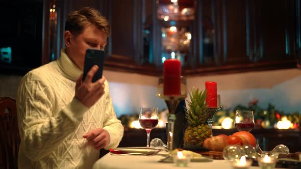 Sad Man Talking on Phone Hanging Up Blowing Out Candle on Table with Romantic Dinner alt