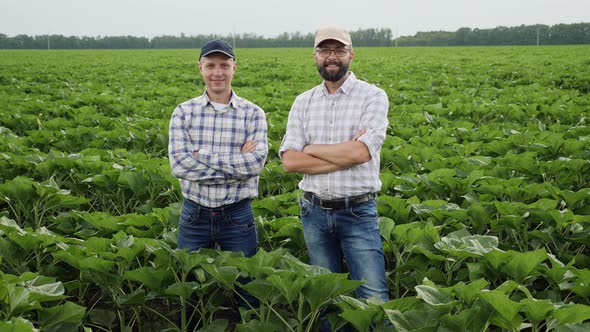 Portrait of Two Smiling Men in a Field alt