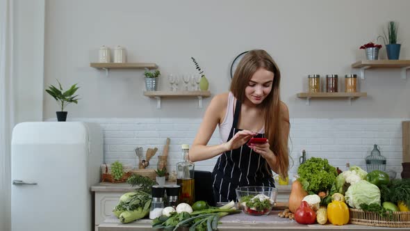 Blogger Woman Preparing Food, Taking Pictures on Phone for Her Social Accounts or Video Stories alt