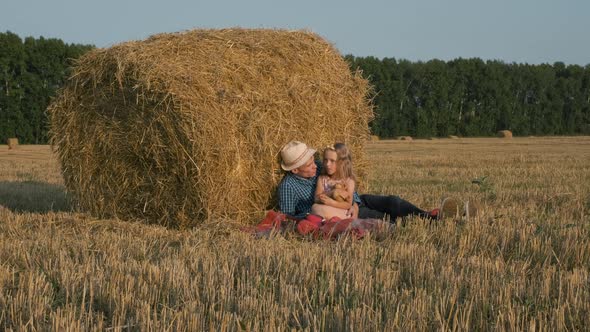 Little Girl with Father Relax in Harvested Field alt