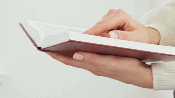 Close Up of Female Hands Turning Pages of a Book alt