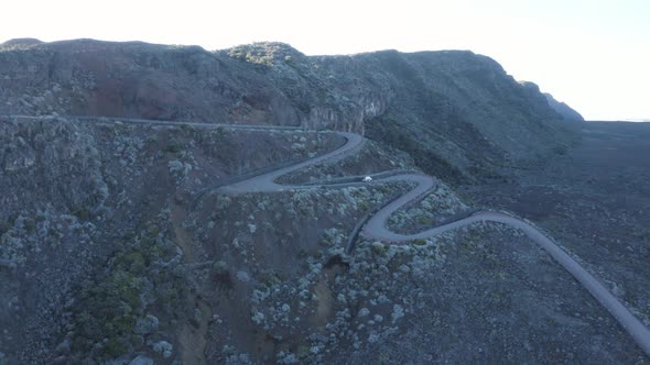Aerial view of a vehicle driving a twisty road, Reunion. alt