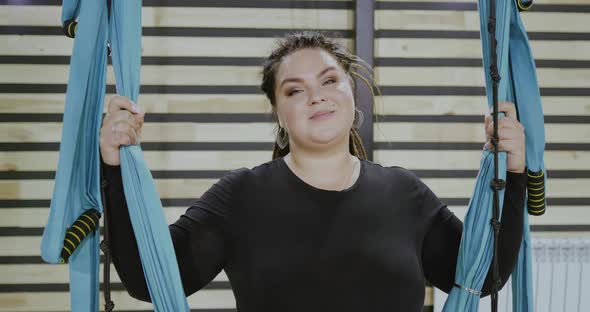 Happy Body Positive Woman Smiling and Laughing After Doing Stretching Exercise on Hammocks alt