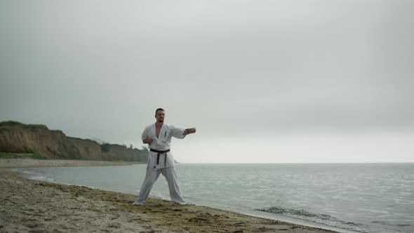 Judo Fighter Doing Workout on Sandy Beach alt
