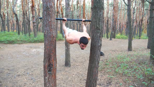 Strong Man Showing Some Gymnastics Stunts on Horizontal Bar. Muscular Guy Doing Gymnastics Elements alt
