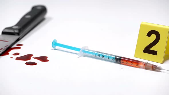 Syringe on a Crime Scene with Drugs and a Knife in the Blood alt