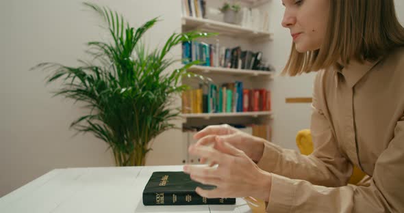 Christian Religious Woman Prays and Reads Holy Bible at Home Studying Scripture
