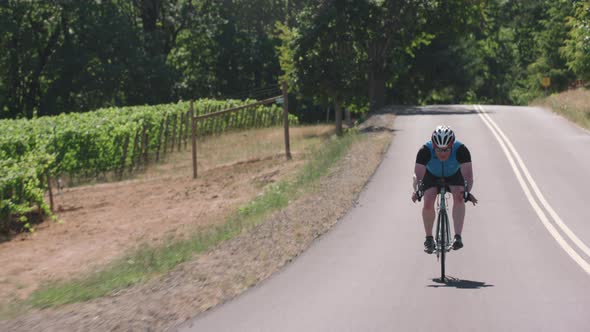 Tracking shot of a male cyclist on country road.  Fully released for commercial use.