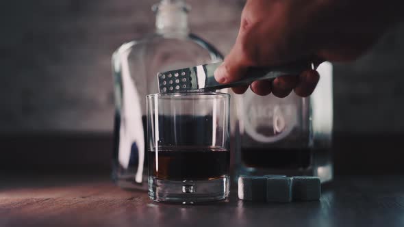 Pouring of Golden Whiskey Cognac or Brandy From the Bottle Into Glass alt
