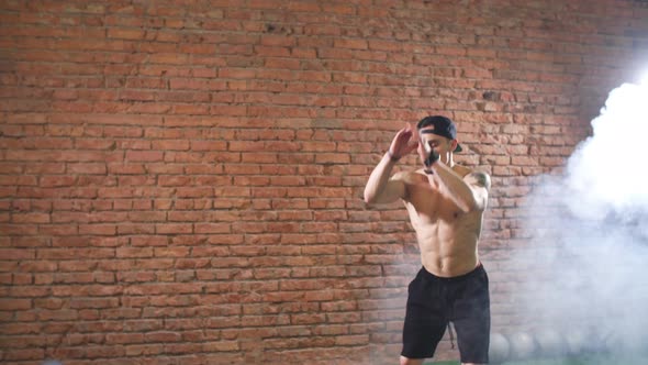 Muscular Male Practicing Plyometric Exercise on Jump Box in Dark Gym alt