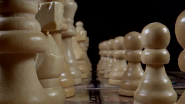 Dolly forward shot between Chess Figures And Chess Pieces Game with black background,macro view alt