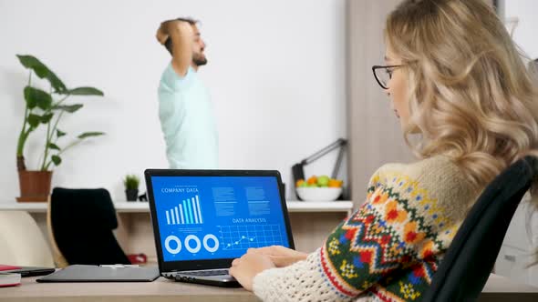 Woman Looking at Animated Financial Chart on the Computer on the Living Room alt