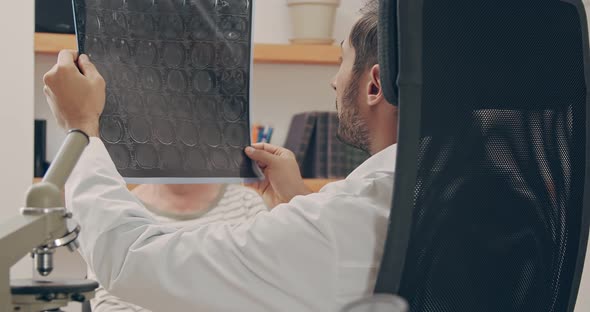 Family Medical Doctor Showing Brain Test Results to a Senior Patient in a Health Clinic alt