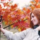 Young Beautiful Woman In Autumn Forest Taking Pictures With Smartphone