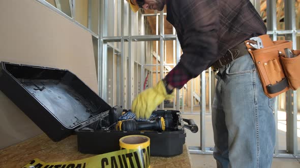 Caucasian Construction Worker Preparing His Tools For the Job alt