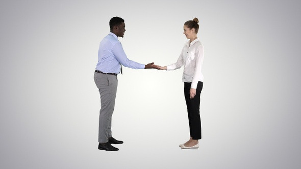 African man and caucasian woman giving low five on gradient alt