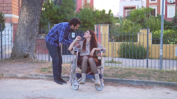 friendship, solidarity - young men join their friend using wheelchair at park alt