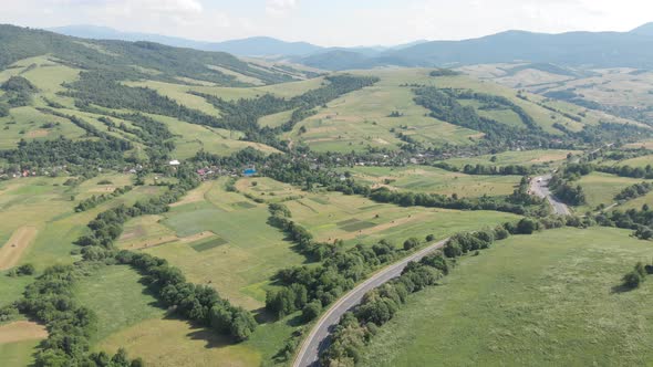 Drone filming of the Carpathian mountains in Ukraine. Cars are driving along the winding road