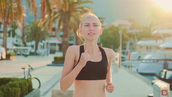 Close Up of Attractive Blonde Woman Jogging Down the Street in Port