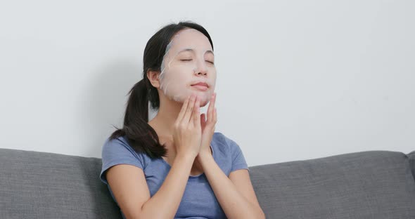 Young Woman apply face mask on face at home alt