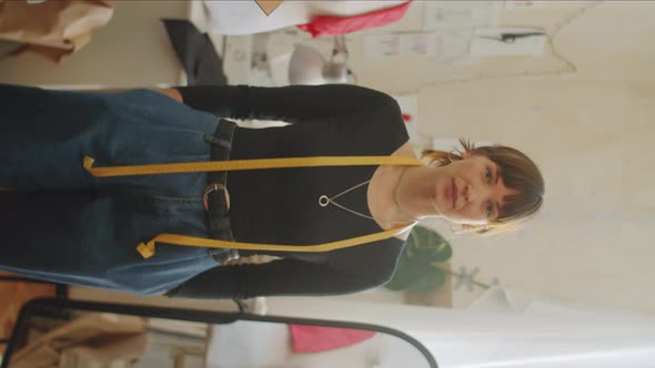 Cheerful Female Dressmaker Posing for Camera in Sewing Studio alt