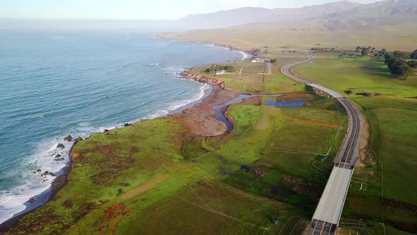 The Cabrillo Highway winds along California ocean beach at sunrise alt