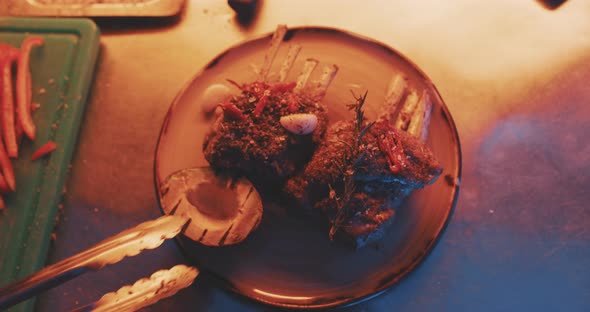 Hands of professional chef plating finished meal alt