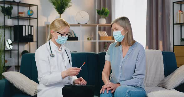 Woman-Doctor in Protective Mask Talking with Her Female Patient Before Injection of Vaccine alt