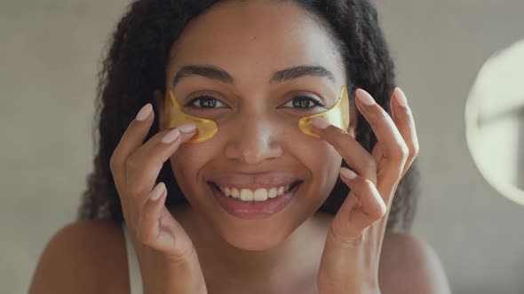 Mirror Pov Portrait of Young Positive African American Lady Putting Collagen Patches on Under Eyes alt