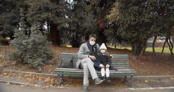 Father and Daughter Wearing Surgical Mask at the Public Park alt