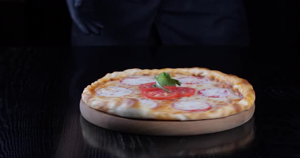 Cropped Shot of Male Hands of Waiter Chef in Black Uniform and Latex Gloves Holding Wooden Round alt