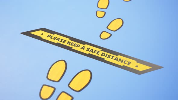 Social distancing floor signs during the coronavirus pandemic.Yellow visual cues alt