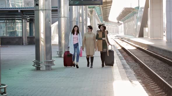 Passengers with Suitcases Walking on the Platform of the Railway Station