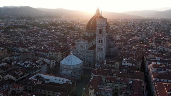 Dramatic Sunrise Sun Flare behind Florence Cathedral Church Building in Italy - Aerial alt