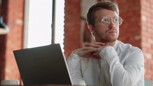 Portrait of Handsome European Man with Glasses and Laptop in Cafe Freelancer is Sitting Alone and alt